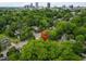 An aerial view of a neighborhood with lush greenery, homes, and a cityscape in the background at 304 Linden Ave, Raleigh, NC 27601