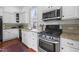 Bright kitchen with white cabinets, granite countertops, and stainless steel appliances at 304 Linden Ave, Raleigh, NC 27601