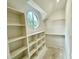 Bright walk-in closet features custom shelving and a round window providing natural light and great outdoor views at 323 Hudson St, Raleigh, NC 27608