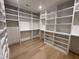Bright walk-in closet features custom shelving and storage solutions with hardwood floors and recessed lighting at 323 Hudson St, Raleigh, NC 27608