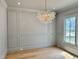 Bright dining room featuring a modern chandelier, wainscoting, and light hardwood floors at 323 Hudson St, Raleigh, NC 27608