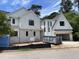 Exterior view of new construction home with white paint, black framed windows and open garage at 323 Hudson St, Raleigh, NC 27608