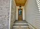 Close up of front door with wood ceiling and gray stone wall feature at 323 Hudson St, Raleigh, NC 27608
