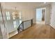 Bright upstairs hallway features hardwood floors, chandelier, and lots of natural light at 323 Hudson St, Raleigh, NC 27608