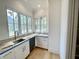 Bright kitchenette features a sink, white cabinetry, light countertops, and a large window offering a pleasant view at 323 Hudson St, Raleigh, NC 27608