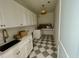 Well-appointed laundry room with stylish black and white floors, white cabinets, and modern fixtures at 323 Hudson St, Raleigh, NC 27608
