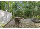 Private backyard featuring a brick patio, dining set, garden beds, and privacy fence at 359 Ashton Ridge Ln, Cary, NC 27513