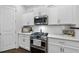 Modern kitchen features stainless steel appliances, white cabinets, and quartz countertops at 359 Ashton Ridge Ln, Cary, NC 27513