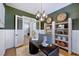 Stylish home office with green walls, modern chandelier, built-in shelving and decorative accents at 361 Murray Grey Ln, Wake Forest, NC 27587