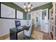 Beautifully decorated home office with a modern chandelier, white wainscoting and large windows at 361 Murray Grey Ln, Wake Forest, NC 27587