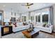 Bright living room featuring white sofas, large windows, and an open layout connecting to the kitchen at 361 Murray Grey Ln, Wake Forest, NC 27587