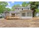 Rear exterior of the house with a large wooden deck, a screened-in porch, and gray siding at 3700 Summer Pl, Raleigh, NC 27604