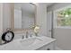 Bright bathroom with a quartz countertop, brushed nickel faucet, and framed mirror at 3700 Summer Pl, Raleigh, NC 27604