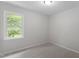 Neutral bedroom with soft carpet, light walls, and a bright window view at 3700 Summer Pl, Raleigh, NC 27604
