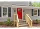 Close up of the front entrance, highlighting the red door, new wooden stairs, and stylish exterior lighting at 3700 Summer Pl, Raleigh, NC 27604