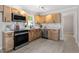 Bright kitchen features stainless steel appliances, wood cabinets, and marble-look countertops at 3700 Summer Pl, Raleigh, NC 27604