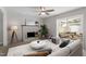 Bright living room with a white brick fireplace, ceiling fan, and sliding glass doors to the sunroom at 3700 Summer Pl, Raleigh, NC 27604