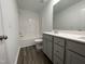 Well-lit bathroom with double sinks, gray cabinets, and a shower-tub combo at 377 Thompson Overlook Way, Smithfield, NC 27577