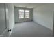 Bright bedroom with plush gray carpeting, two windows and neutral wall paint at 377 Thompson Overlook Way, Smithfield, NC 27577