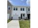Well-maintained townhouse with white siding, a front-facing garage, and a small green lawn at 377 Thompson Overlook Way, Smithfield, NC 27577