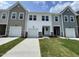 Three townhouses featuring diverse siding, attached garages and freshly cut green lawns on a bright day at 377 Thompson Overlook Way, Smithfield, NC 27577