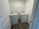 A bright laundry room featuring a washer, dryer, wire shelving, and wood-look vinyl flooring at 377 Thompson Overlook Way, Smithfield, NC 27577