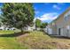 A backyard with a grassy slope in a townhouse community with mature landscaping at 3806 Bison Hill Ln, Raleigh, NC 27604