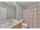 Well-lit bathroom featuring a single sink vanity, toilet, and shower with patterned curtain at 3806 Bison Hill Ln, Raleigh, NC 27604