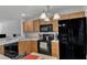 Inviting kitchen featuring wood cabinets, black appliances, and ample counter space for meal preparation at 3806 Bison Hill Ln, Raleigh, NC 27604