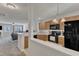 Open kitchen area with black appliances and view into living space at 3806 Bison Hill Ln, Raleigh, NC 27604