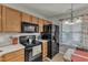 Well-appointed kitchen featuring wood cabinets, black appliances, and a cozy dining nook with natural light at 3806 Bison Hill Ln, Raleigh, NC 27604