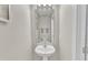 Stylish powder room featuring a pedestal sink, elegant mirror, and neutral tones for a clean and modern look at 3806 Bison Hill Ln, Raleigh, NC 27604