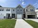 New construction townhomes featuring attached garages, neutral color palettes, and manicured lawns at 381 Thompson Overlook Way, Smithfield, NC 27577