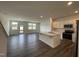 Open-concept living room with white cabinets, stainless steel appliances, and island at 381 Thompson Overlook Way, Smithfield, NC 27577