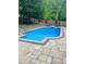 Backyard swimming pool with stone surround, diving board, and fenced perimeter at 404 Versailles Dr, Cary, NC 27511