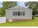 Rear view of home with gray siding, black shutters, and a well-maintained grassy area at 4048 B S Nc 62 Hwy, Burlington, NC 27215