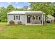 Charming single story home with a manicured lawn and a cozy front porch with rocking chairs at 4048 B S Nc 62 Hwy, Burlington, NC 27215