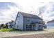 A backyard with a gray house, grass, and a clear sky at 436 Longleaf Glen Lane, Zebulon, NC 27597