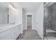 Bright bathroom featuring double vanity, walk-in closet, and glass shower with tiled walls and shower seat at 436 Longleaf Glen Lane, Zebulon, NC 27597
