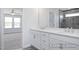 Bathroom featuring a double vanity with white countertops and cabinets and a view into the bedroom at 436 Longleaf Glen Lane, Zebulon, NC 27597