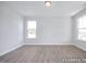 Bright bedroom featuring wood-look floors and two windows providing natural light at 436 Longleaf Glen Lane, Zebulon, NC 27597