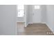 Clean entryway with light wood floors, white walls, and a front door with glass panels at 436 Longleaf Glen Lane, Zebulon, NC 27597