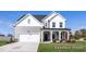 Charming two-story home with a covered porch, attached garage, and well-manicured lawn at 436 Longleaf Glen Lane, Zebulon, NC 27597
