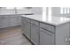 Kitchen island with gray cabinets, stainless steel hardware, and quartz countertop at 436 Longleaf Glen Lane, Zebulon, NC 27597