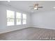 Open living room with three large windows and a ceiling fan for added comfort at 436 Longleaf Glen Lane, Zebulon, NC 27597