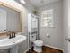 This half-bathroom features wood-look flooring, a pedestal sink, a linen cabinet, and a window for great lighting at 46 Blaze Ridge Dr, Smithfield, NC 27577