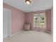 This empty bedroom features neutral carpet, a side table, and a window with decorative curtains at 46 Blaze Ridge Dr, Smithfield, NC 27577