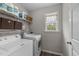 Efficient laundry room with washer, dryer, storage shelves, and a bright window at 46 Blaze Ridge Dr, Smithfield, NC 27577