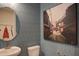 Stylish powder room with patterned wallpaper, modern fixtures, and a round mirror at 4628 Rogers Rd, Wake Forest, NC 27587