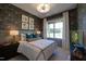 Stylish bedroom featuring accent wallpaper, a cozy bed, and modern lamps at 4628 Rogers Rd, Wake Forest, NC 27587